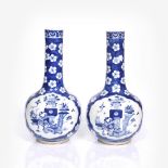 A pair of Chinese blue and white porcelain bottle vases 19th Century each having a reserve panel