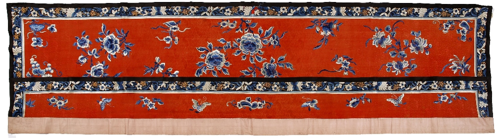 A Chinese red ground embroidered panel late 19th Century with sprays of peonies within blue panel