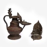 An Indian copper jug 19th Century with open spout having ceremonial Ganesh above and to the thumb-