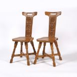 Malcolm 'Foxman' Pipes Pair of carved oak hall chairs the backs carved with scrolling flowers