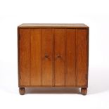 Heals Oak cupboard, circa 1920 panelled front with turned handles, on bun feet 'Heal & Sons' ivorine