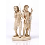 A Japanese walrus ivory group late 19th Century of two ainu standing holding an axe, bows and