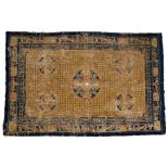 A Chinese rug 18th/19th Century gold ground with archaic designs and blue border, 152m x 222cm