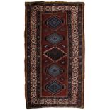 A Kazak red ground rug with five medallions with kufic border, 270cm x 140cm