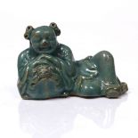 A Chinese green glazed model of a boy 19th Century Shiwan ware, the boy resting his hands on the