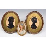 A PAIR OF 19TH CENTURY OVAL MINIATURE SILHOUETTE PORTRAITS of a lady and gentleman, heightened in