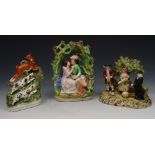 A STAFFORDSHIRE POTTERY GROUP of a christening party, 15cm h; and two further groups, 21.5cm and