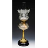 A VICTORIAN BRASS OIL LAMP, with lobed and foliate embossed decoration and cut glass reservoir, on