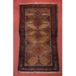 A KURDISH CAMEL GROUND RUG with four hooked medallions within a triple border, 200cm x 107cm