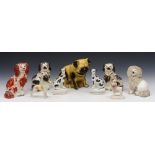 A GROUP OF NINE CERAMIC MODELS of dogs including three seated Staffordshire spaniels, 17cm to 8cm