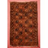 AN AFGHAN FADED RED GROUND RUG with two rows of octagonal medallions within a geometric border,