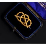 A LATE VICTORIAN GOLD KNOT BROOCH, modelled as a ropetwist knot, the reverse stamped '15ct', in