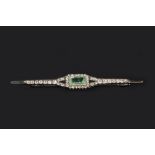 AN EMERALD AND DIAMOND BAR BROOCH, centred with a rectangular step-cut emerald and single-cut