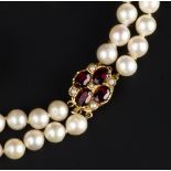 A CULTURED PEARL DOUBLE STRAND NECKLACE, with an oval mixed-cut garnet and half pearl cluster clasp,