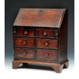 A GEORGE III APPRENTICE MINIATURE MAHOGANY BUREAU with fitted interior and six drawers, 30cm wide