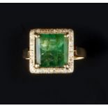 AN EMERALD AND DIAMOND CLUSTER RING, the square step-cut emerald claw set within a brilliant-cut