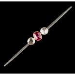 A SYNTHETIC RUBY AND DIAMOND THREE STONE BAR BROOCH, the oval mixed-cut synthetic ruby in millegrain