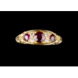A RUBY AND DIAMOND HALF HOOP RING, the trio of circular mixed-cut rubies spaced by pairs of single-