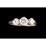 A DIAMOND THREE STONE RING, the graduated round brilliant-cut diamonds in claw setting, two colour