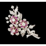 A RUBY AND DIAMOND FLORAL SPRAY BROOCH, centred with three flowerheads of circular and oval mixed-