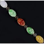 A JADE PANEL BRACELET, the oval jade panels alternating in shades of green, lilac, reddish-orange,