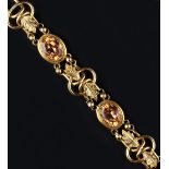 A FANCY-LINK BRACELET, comprising a line of oval openwork links applied with foliate panels,