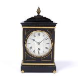 A REGENCY STYLE EBONISED AND BRASS MOUNTED TIMEPIECE with circular steel dial and Roman numerals