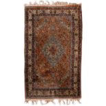 A PERSIAN CAMEL GROUND RUG the central blue medallion within a field of scrolling flowers and