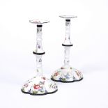 A PAIR OF ENAMEL CANDLESTICKS with loose sconces, baluster stems and inverted bases, 17cm high (2)