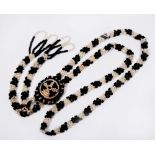 A NORTH AMERICAN NATIVE BLACK AND WHITE BEAD NECKLACE of alternating panel form with central rosette