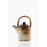 John Maltby (b.1936) Teapot painted cross motif, cane handle impressed potter's seal 16cm across.