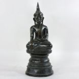 An antique patinated bronze model of a Thai Buddha, shown seated, on a plinth base,