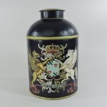 A painted metal canister, decorated with a coat of arms,