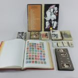 An album of all world stamps, together with a collection of postcards,