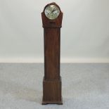 An early 20th century walnut cased granddaughter clock, with Westminster chimes,