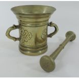 An 18th century turned brass pestle and mortar, of flared shape,