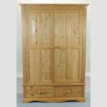 A pine double wardrobe, with two drawers below,