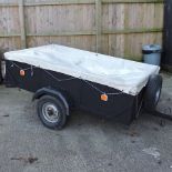A wooden car trailer, with a tarpaulin cover,