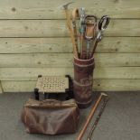 A leather stick stand, containing a collection of various walking sticks,