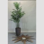 A faux palm, in a reconstituted stone pot,