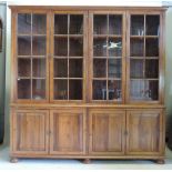A Harrods reproduction yew wood library bookcase, enclosed by four glazed doors,