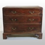 A George III mahogany chest, containing three long graduated drawers, on bracket feet,