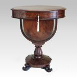 A William IV mahogany ladies work table, of oval shape, on a U shaped support and platform base,