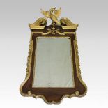 A George II mahogany and parcel gilt wall mirror, the rectangular plate having a gilt slip,