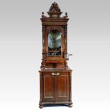 A late 19th century German walnut cased standing polyphon, enclosed by an arched glazed door,
