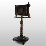 A 19th century turned wooden zograscope, on ball feet,