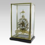 A brass skeleton clock, having enamel hours, surmounted by a bell, contained in a glazed case,