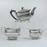 A George III silver three piece tea service, of half gadrooned rectangular shape,