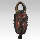 An antique carved and painted wooden tribal mask,