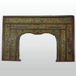 An antique Indian ornately carved wooden and polychrome painted opium bed entrance,